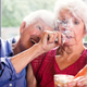 Two senior girlfriends 83 years old smoke medicinal marijuana together. One of them shows the other how to do. The old lady is surprise and making a face. They have hair and wear casual clothes. The recreational marijuana become legal in Canada next autumn. Photo was taken in Quebec Canada.